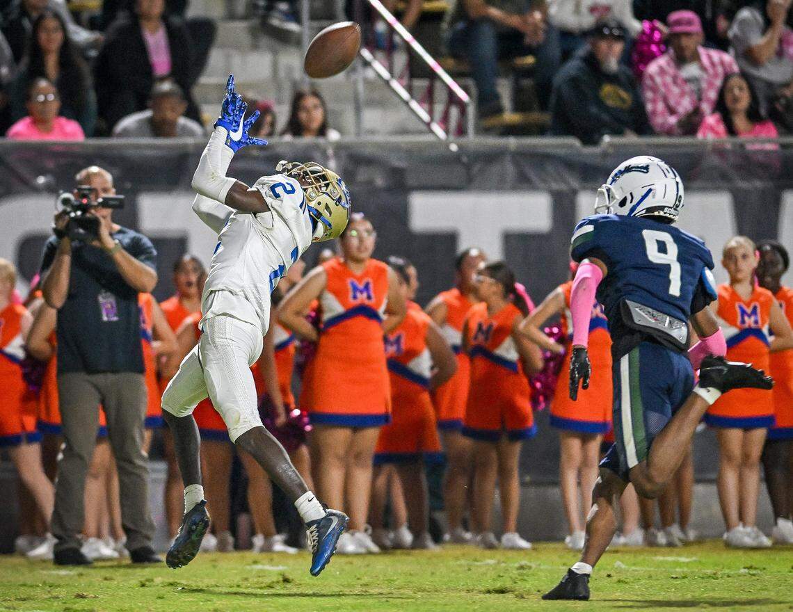 Clovis' Carlos Young, left, reaches up to catch the ball before rolling into the end zone for a touchdown while being trailed by Clovis East's Dharri Greathouse during their game at Lamonica Stadium in Clovis on Friday, Oct. 17, 2025.