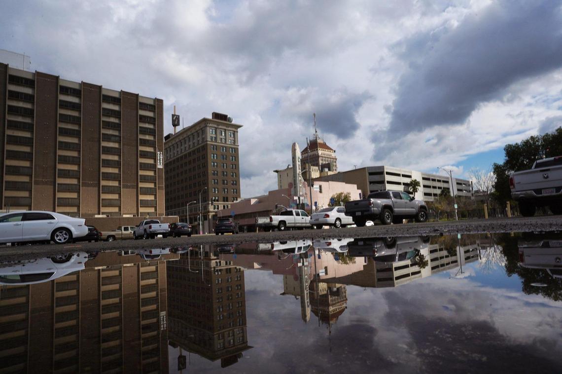 The downtown Fresno skyline is reflected between storms Friday, Dec. 24, 2021 in Fresno.