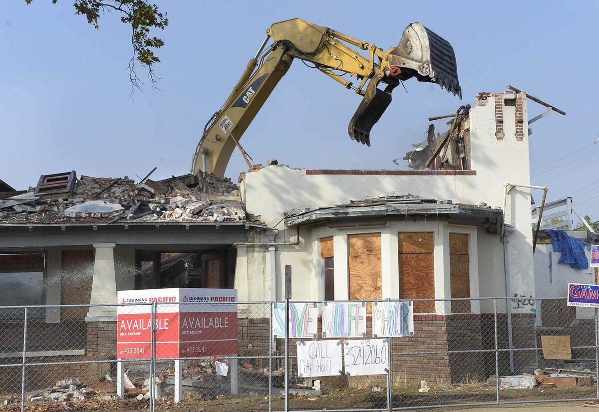 As the claws of the excavator tear into the last remains of Wolfe Manor in Clovis in 2014, a sign in front implores people to “Save Wolfe Manor” and to call city hall.