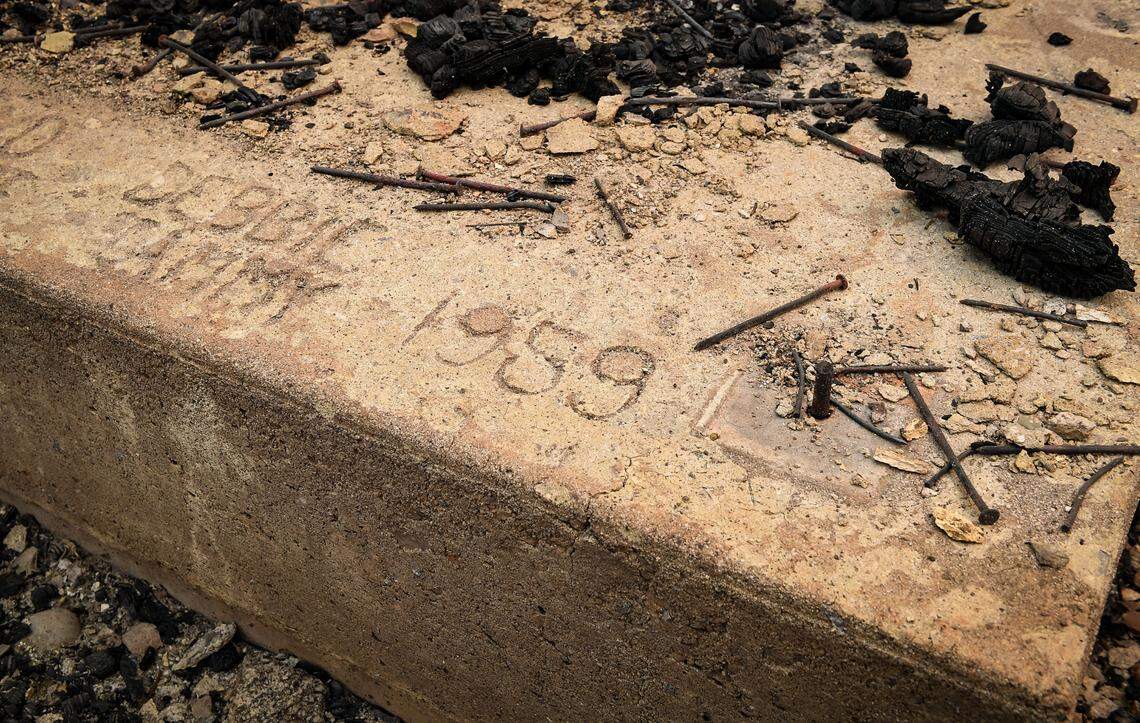 Names and a date of 1959 are marked in a foundation of a burned cabin in the Camp Silver Fir area on the north of Huntington Lake on Sunday, Sept. 13, 2020. Fire officials said a fire tornado blew through the area at some point last week burning cabins and knocking down many trees.
