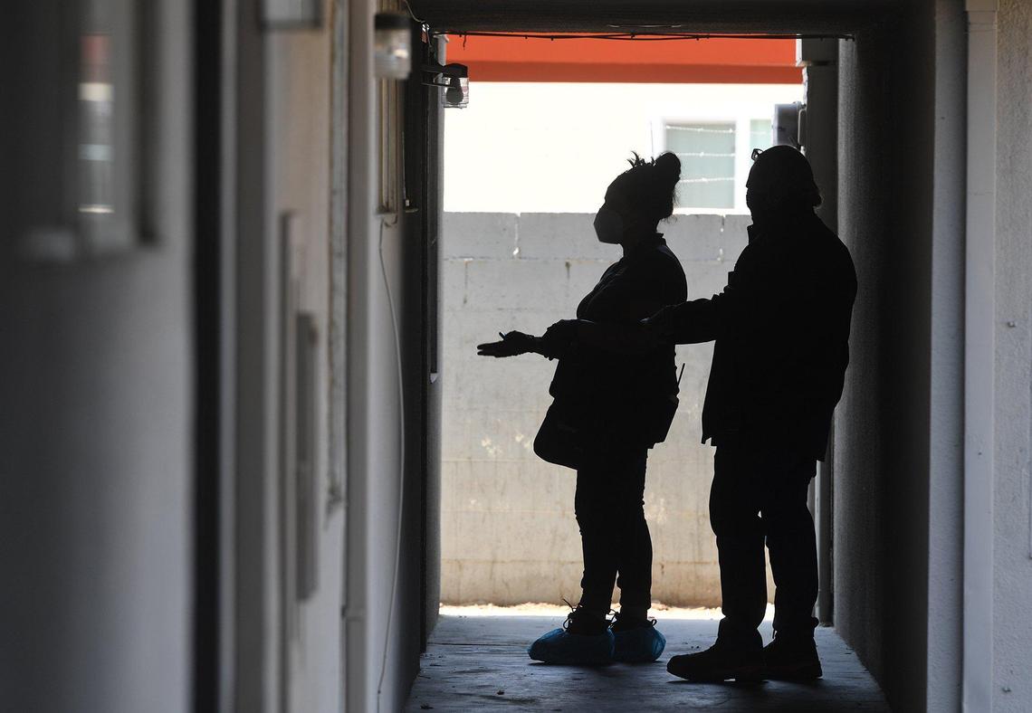 Two inspectors from the Fresno Code Enforcement department talk with a Manchester Arms tenant during a re-inspection to confirm that violations within the units have been corrected, Thursday June 17, 2021.