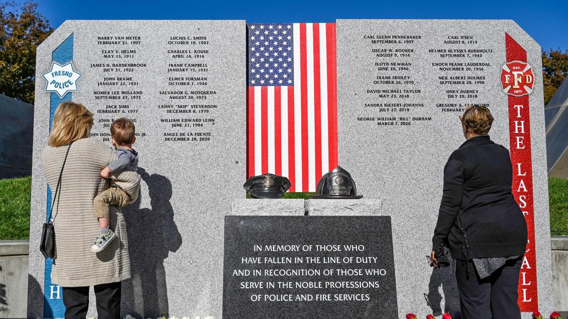 Family members take a close look at the names inscribed on the new First Responders Memorial honoring city police officers and firefighters who lost their lives after an unveiling ceremony outside Fresno City Hall on Wednesday, Nov. 2, 2022.