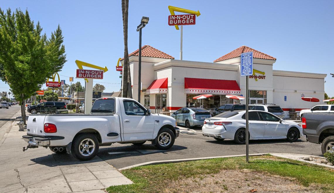 Cars are backed up into Shaw Avenue while waiting to get to the drive-thru window at In-N-Out Burger on west Shaw Avenue near Highway 99 in Fresno on Monday, Aug. 7, 2023. Traffic issues have occurred in the area for years as vehicles wait in the drive-thru line. But the business just received approvals to increase the length of the drive-thru and add 37 parking spaces.