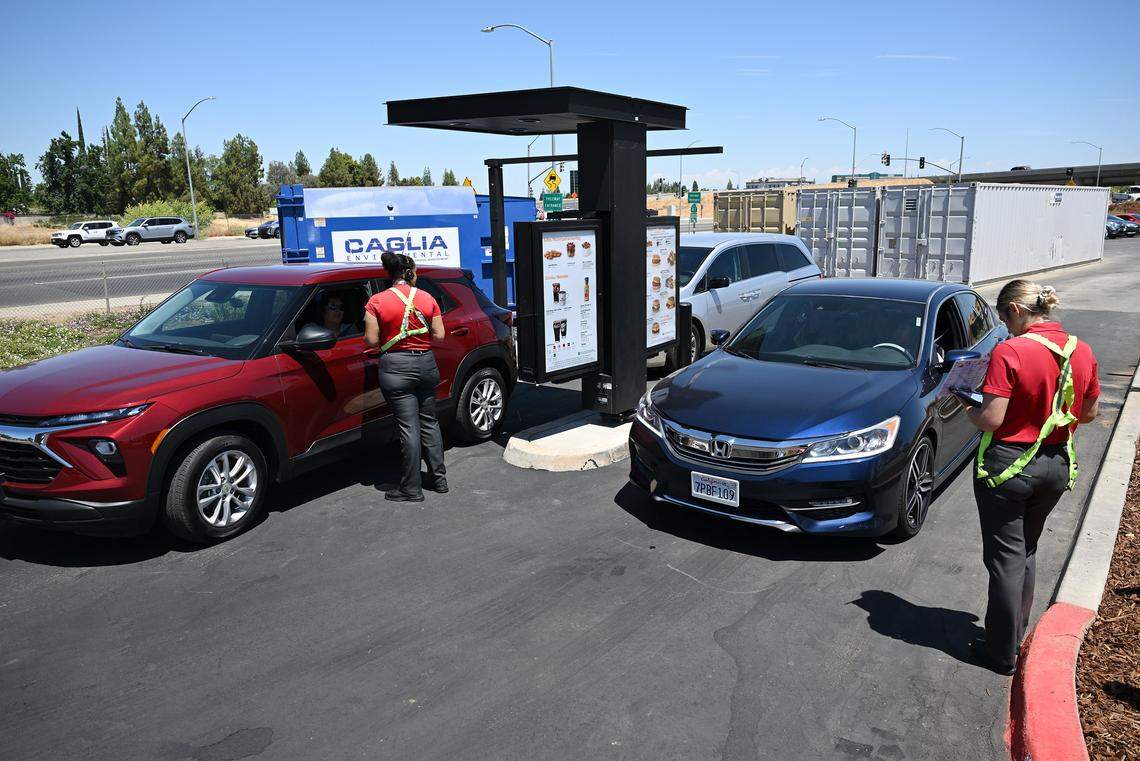 Staff take orders next to the new ordering kiosk at the Chick-fil-A on north Blackstone Avenue at Nees Avenue which has re-opened after being closed for just over four months. The ordering station has been moved away from the main structure to allow more time for orders to be completed before a customer arrives at the payment windows. Photographed Tuesday, July 29, 2025 in Fresno.
