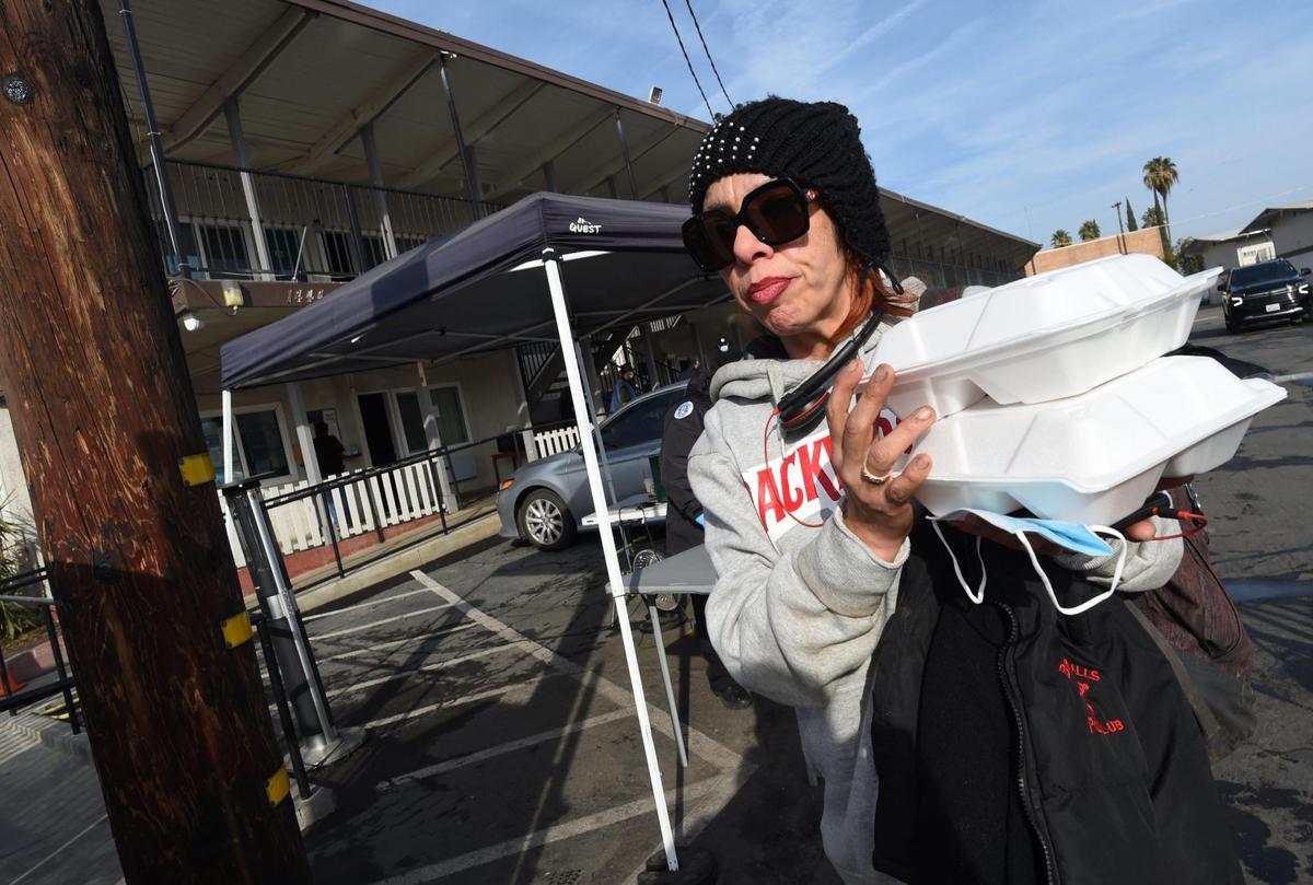 Alicia Zuelzky, formerly homeless, gets her breakfast from the office at the Travelers Inn Triage Shelter, Jan. 28. 2022. The former Travelers Inn motel, now part of the Project Homekey program, provides food, shelter, and transportation, while permanent housing solutions are found working with case mangers.