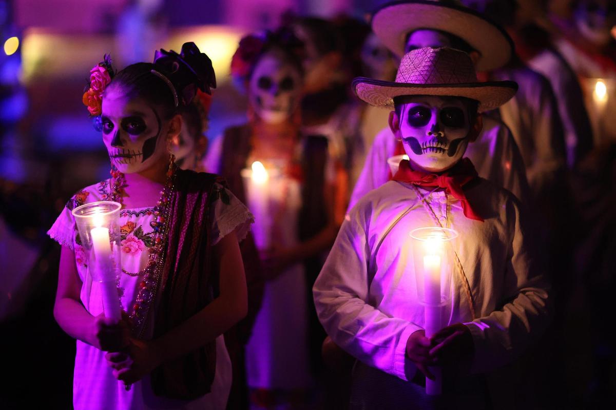 Personas disfrazadas de catrinas participan en el tradicional Paseo de las Ánimas, este jueves en Mérida (México). El Paseo de las Ánimas es una tradición en la que las personas portan el traje regional del estado de Yucatán con la cara pintada de calaveras para recordar sus seres queridos en el Día de Muertos. 