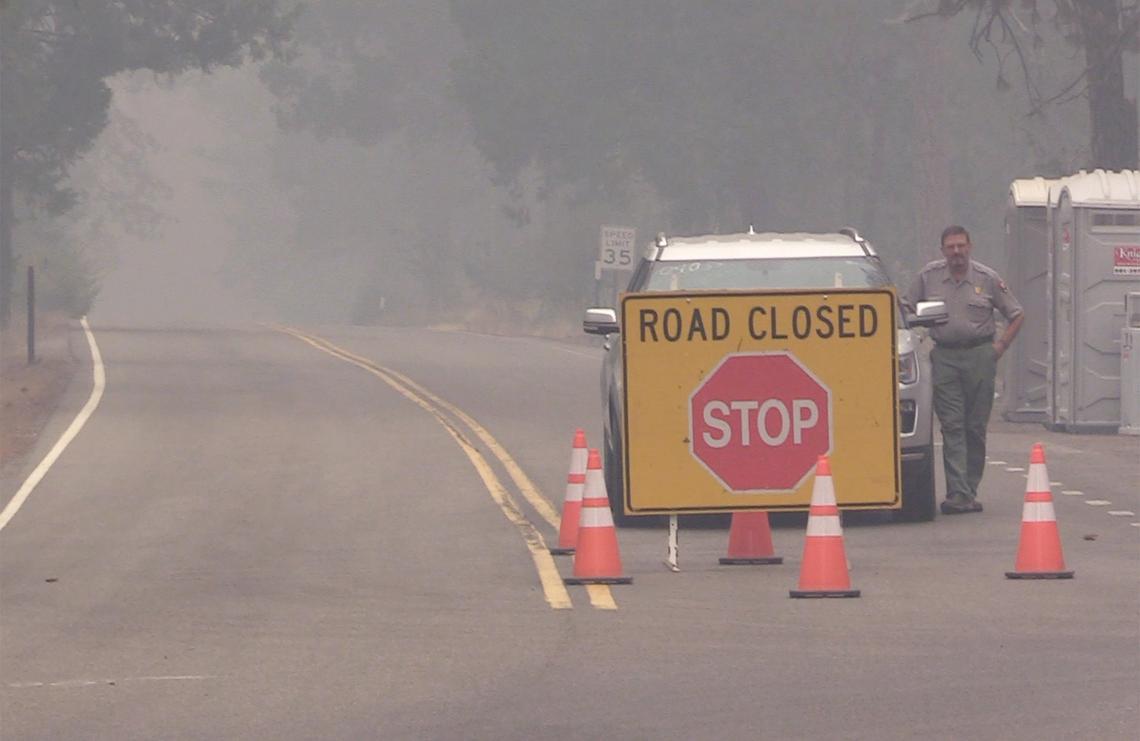 A National Park Service officer keeps watch over the road closure on Highway 41 at Wawona in Yosemite National Park on Monday, Aug. 6, 2018. The road was reoponed Friday, Aug. 25.