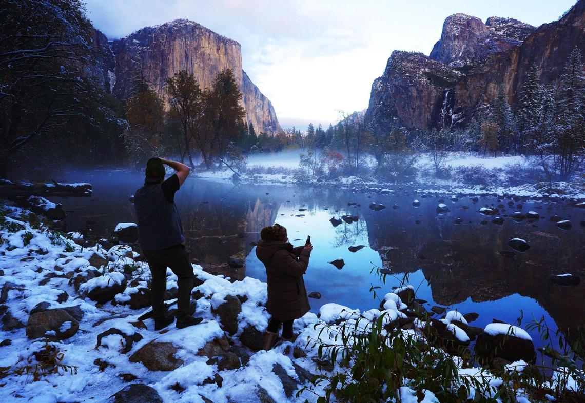 Seattle, Washington’s Erick Jensen, left, and Los Angeles’ Ruth Reyes, right, prepare to photograph the sunset in Yosemite Valley Monday, Nov. 9, 2020 following the weekend’s snowstorm in Yosemite National Park.