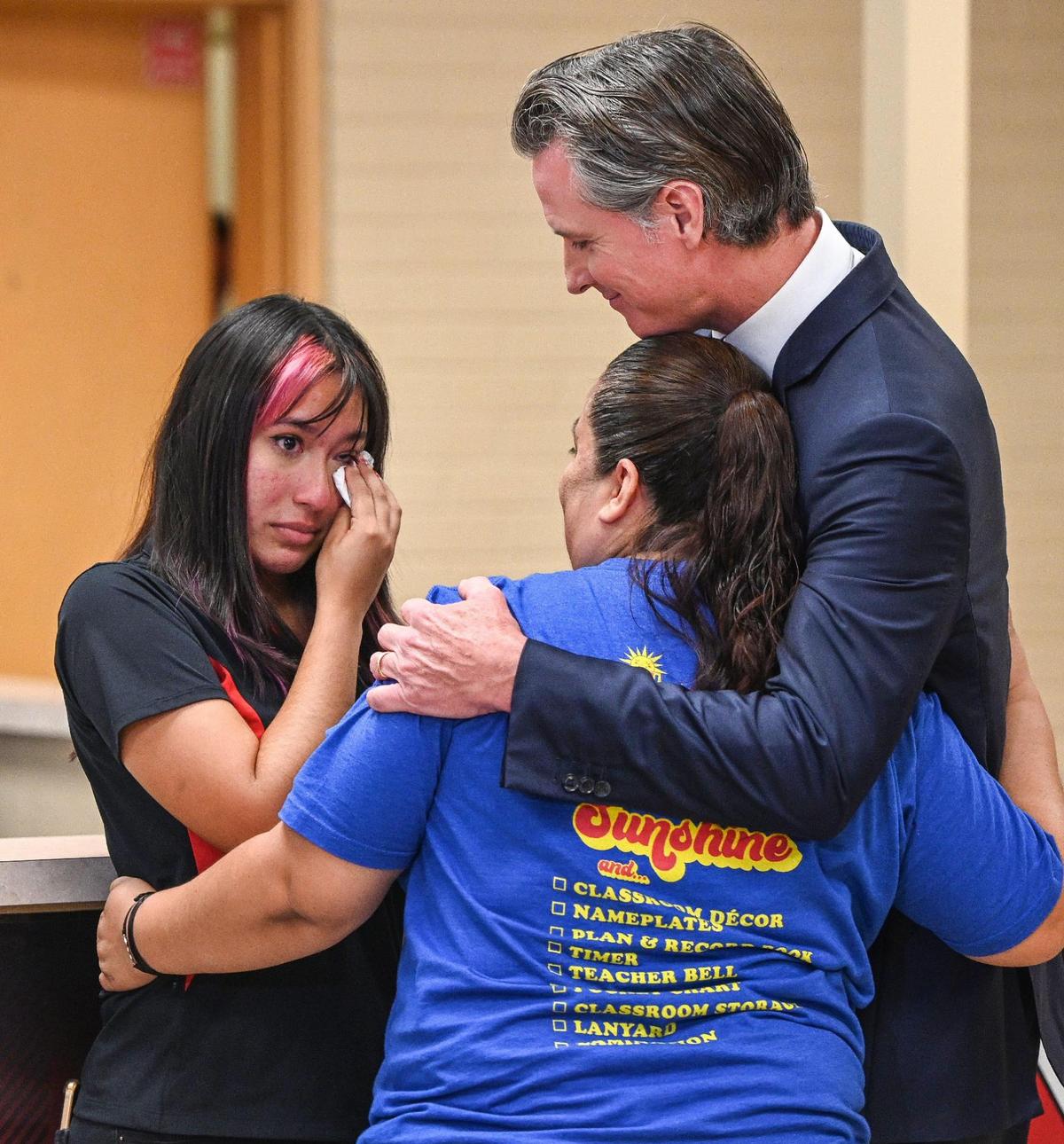 Gov. Gavin Newsom, right, hugs Veronica Barajas, mother, of McLane High School senior Aliyah Barajas, who shared her experiences with depression and self-harm in her youth, during a press conference where the governor announced new funding for mental health and substance abuse support for young Californians, at the school in Fresno on Thursday, Aug. 18, 2022.