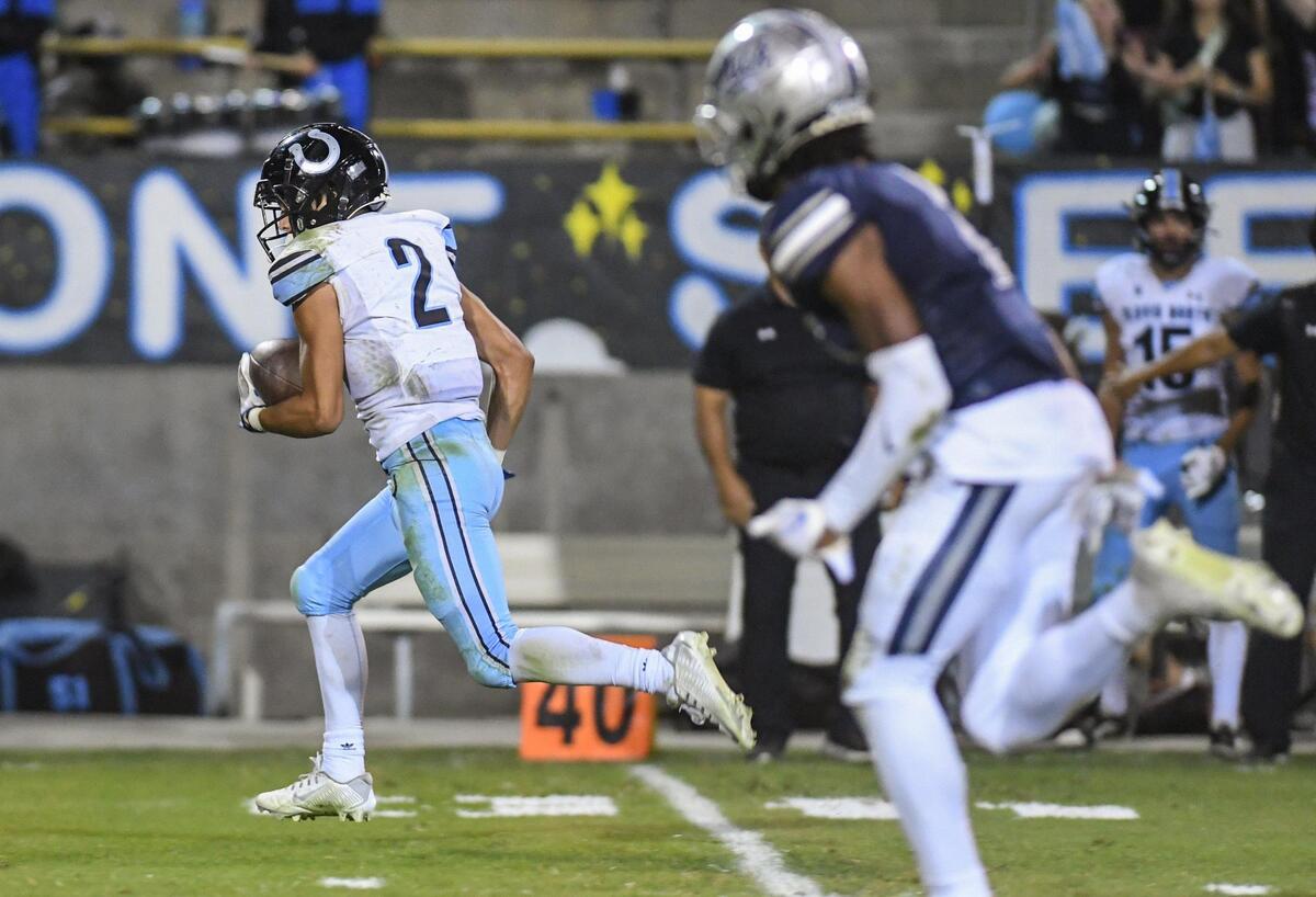Clovis North’s Vincent Cordoba, left, takes the ball down field after a catch against Clovis East during their TRAC opener at Lamonica Stadium on Friday, Sept. 29, 2023.