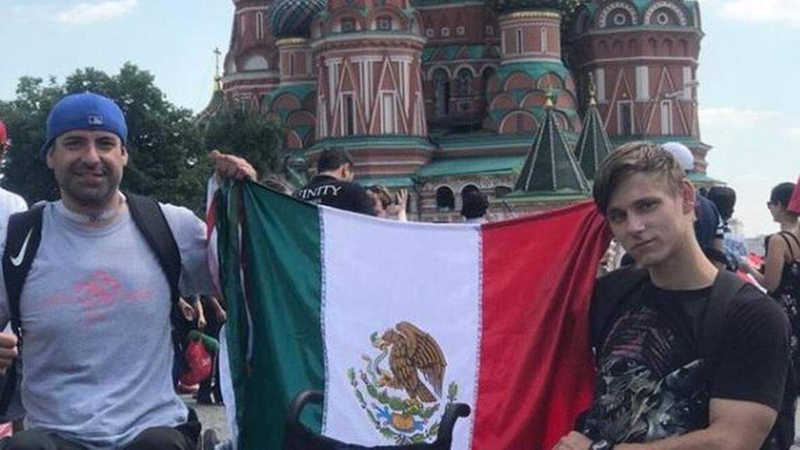 Abel Vera, left, and a Russian man, right, hold up the Mexican flag. Vera traveled to Russia during the FIFA World Cup 2018 and gave the Russian man a wheelchair as a gift.