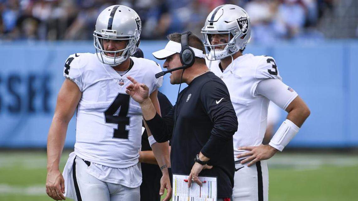 Las Vegas Raiders head coach Josh McDaniels talks with quarterback Derek Carr in the second half of an NFL football game against the Tennessee Titans Sunday, Sept. 25, 2022, in Nashville, Tenn.