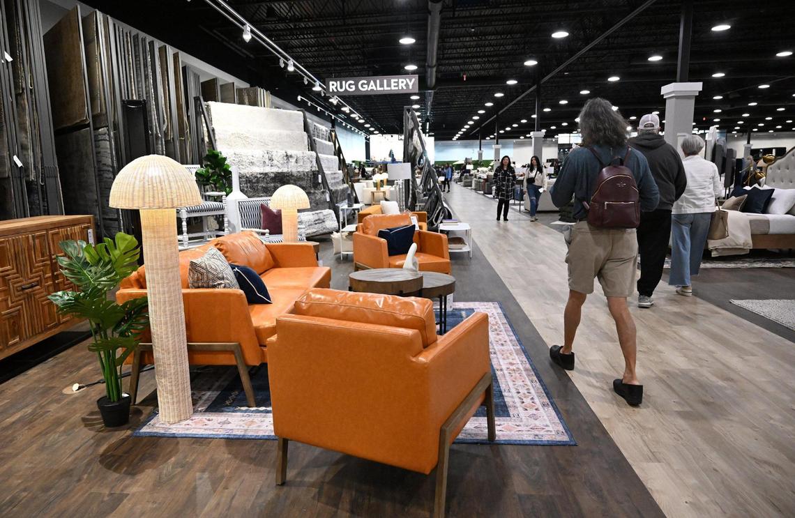 A shopper walks past an orange leather sofa and chairs during Friends & Family night for Living Spaces, a new furniture store in north Fresno Wednesday, Feb. 5, 2025 in Fresno. The expansive showroom includes a children’s play area and cafe serving family-friendly food plus beer and wine for adults. The grand opening is 10am Friday morning, Feb. 7, 2025.
