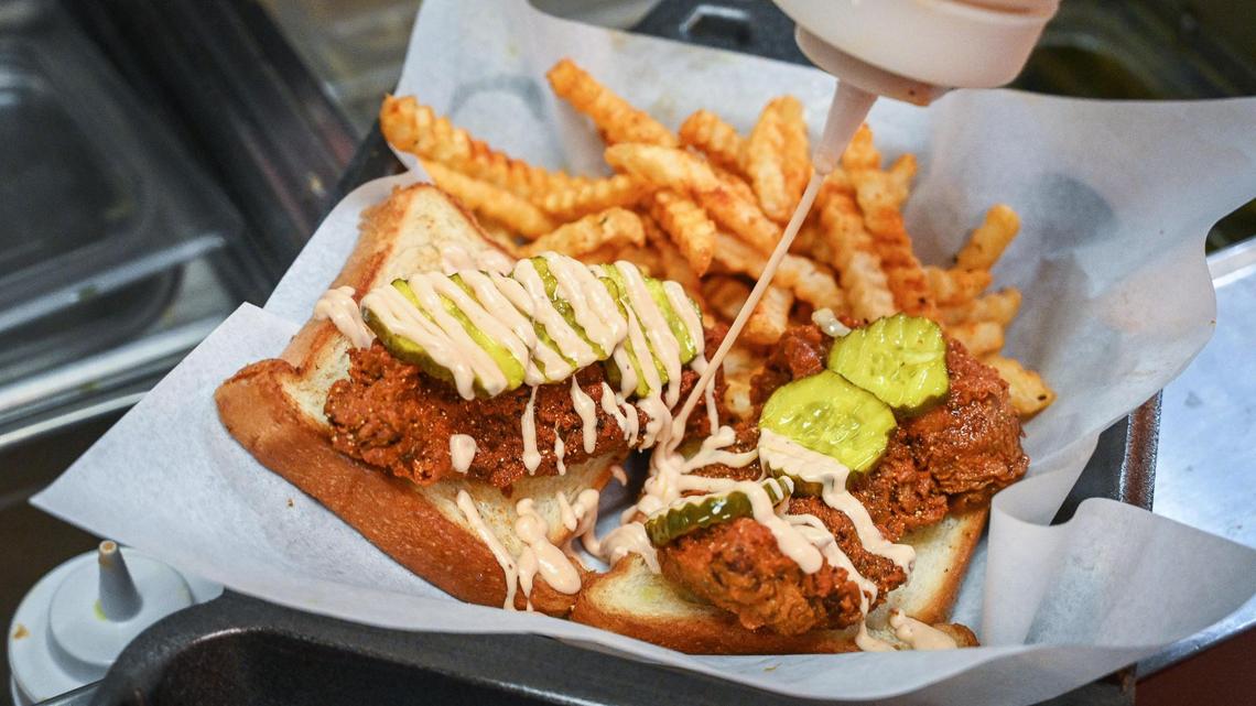 Sauce is applied to Nashville tenders with fries at Fluckers Nashville Hot Chicken in Fresno on Wednesday, April 13, 2022. The new chicken tender restaurant recently moved into the former 559 Taqueria at Shepherd and Cedar avenues.