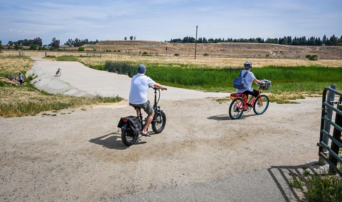 Cyclists ride along one of the river access trails in the San Joaquin River Conservancy’s Jensen River Ranch area next to the San Joaquin River just to the north of Woodward Park in Fresno on Wednesday, April 20, 2025.