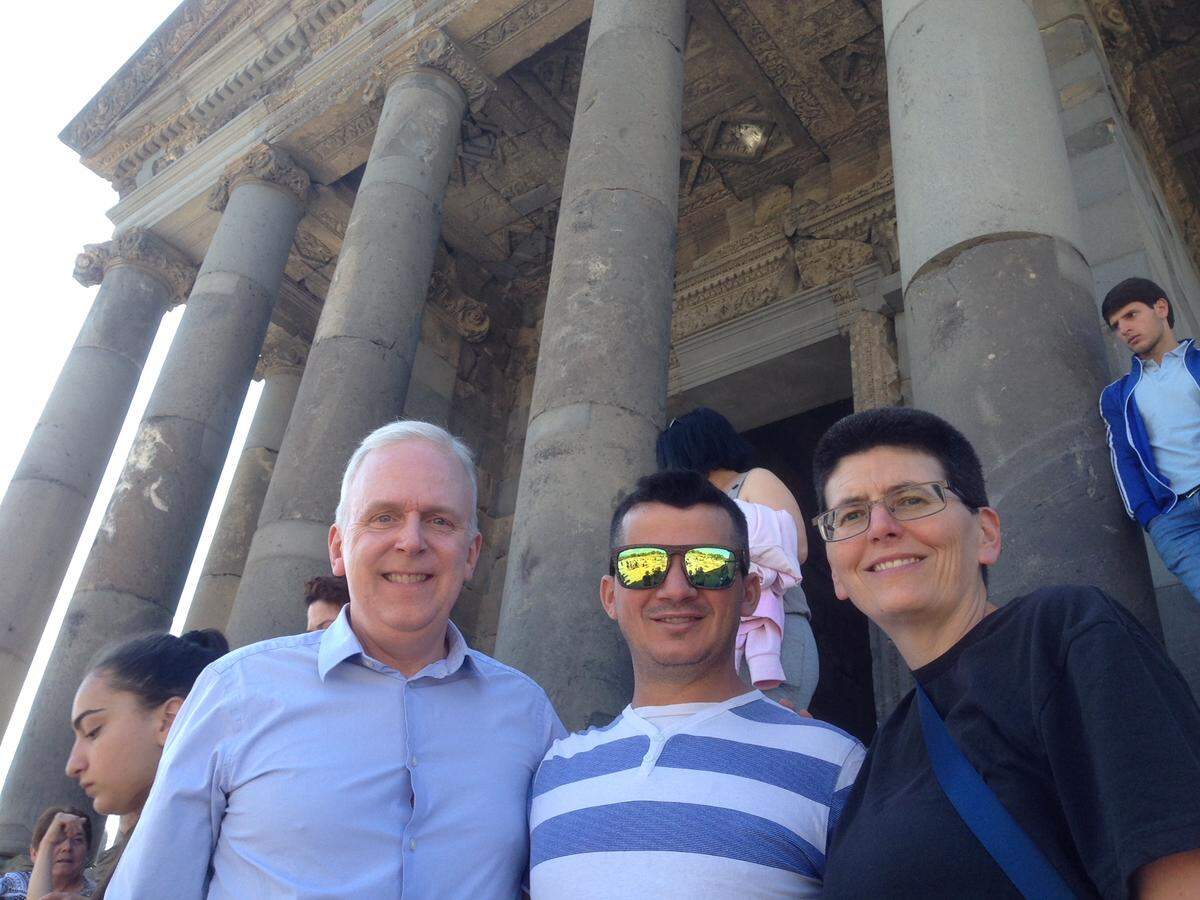 Mark Mitchell, left, with husband Paulo Mendonca, center, and sister Melissa Mitchell while visiting a temple in Armenia last year.