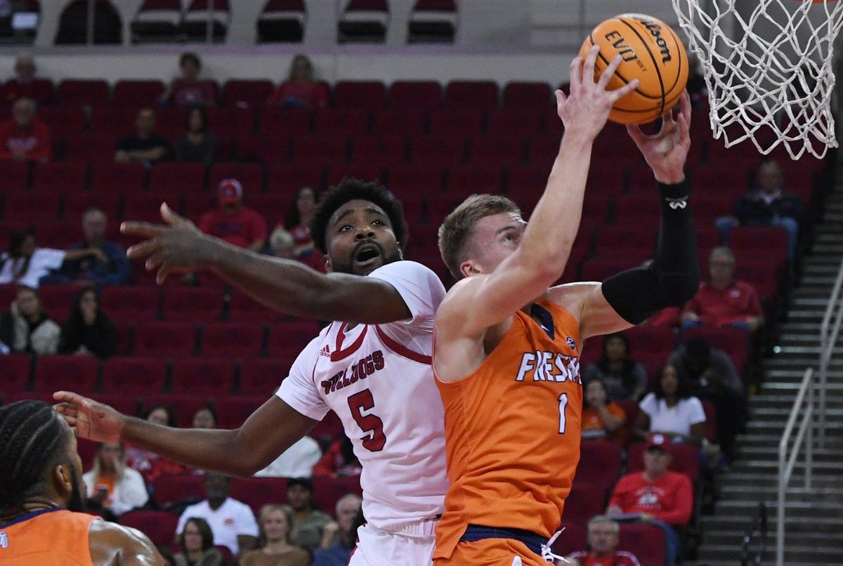 Fresno Pacific guard Marten Maide, right, grabs a rebound from Fresno State guard Jordan Campbell, left, Monday, Nov. 7, 2022 in Fresno.