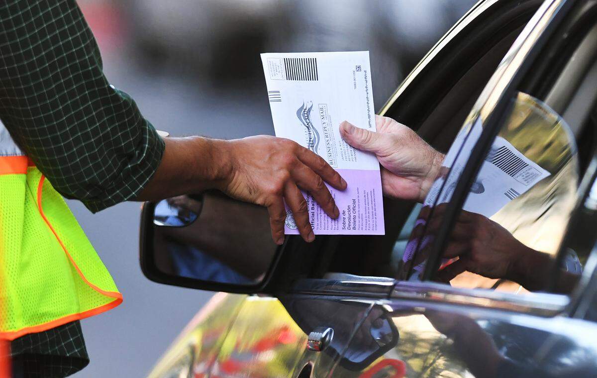 A voter drops off a ballot at the Fresno County Elections drive-thru station on Kern Street on Tuesday, June 7, 2022 in downtown Fresno.