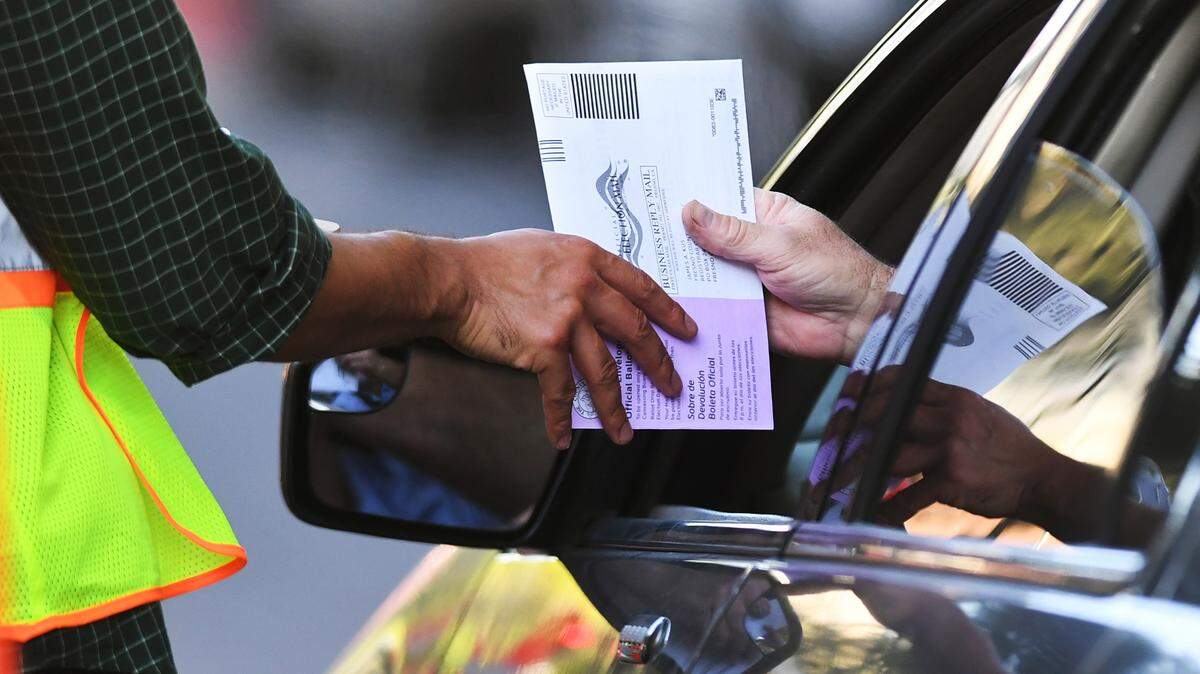 A voter drops off a ballot at the Fresno County Elections drive-thru station on June 7 in downtown Fresno.