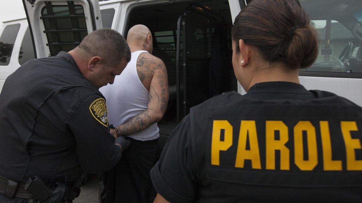 Parole and special service agents from the state Department of Corrections and Rehabilitation take a parole violator to jail in July 2012.