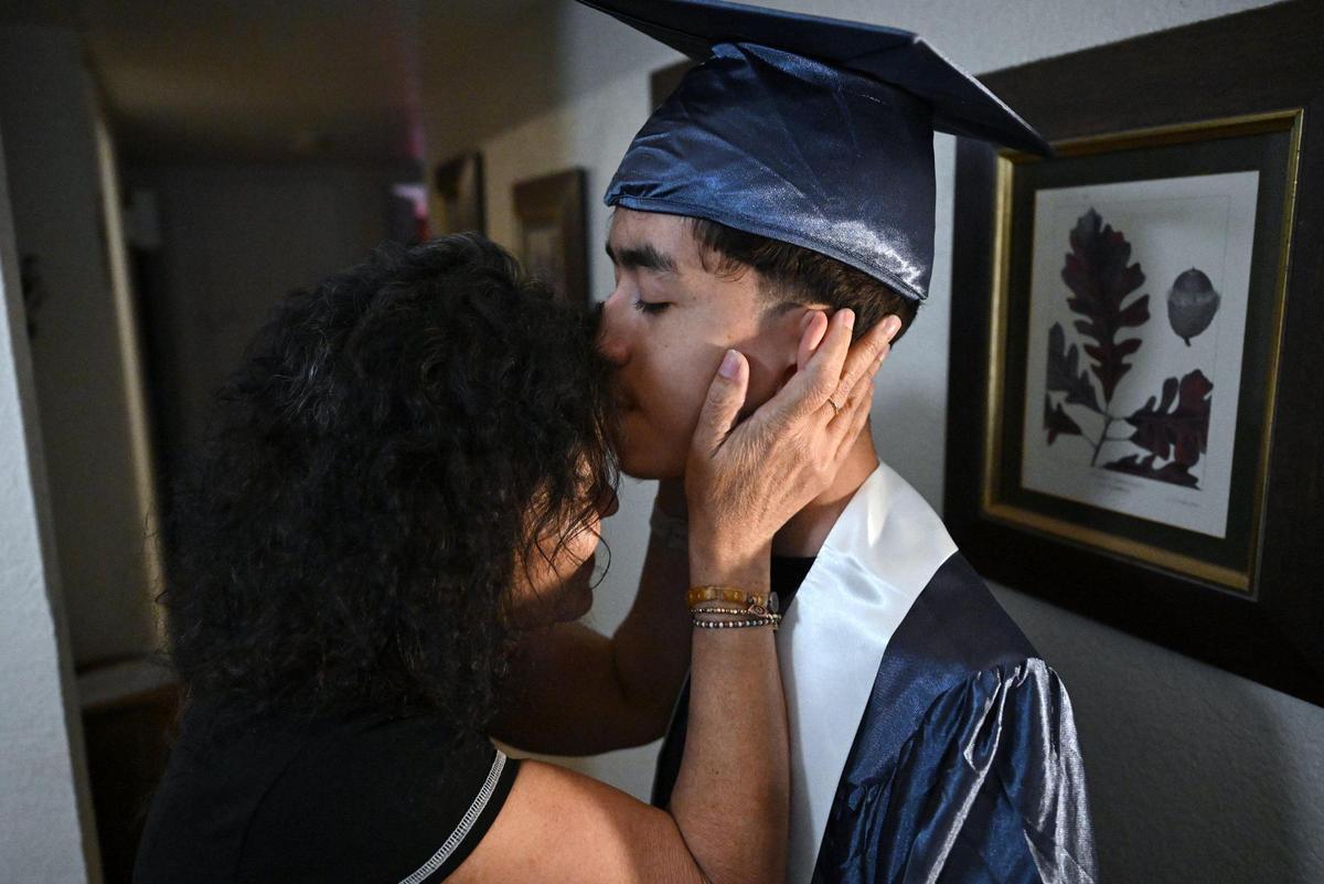 Maria Alvarado leans into her son Cruz Hernandez as he wears the cap and gown for that night’s graduation ceremony from Bullard High School. Cruz and his mother are traveling to Washington DC to advocate for Medical which helped pay for Cruz’ fight against Neurofibromatosis (NF1, a rare disease.