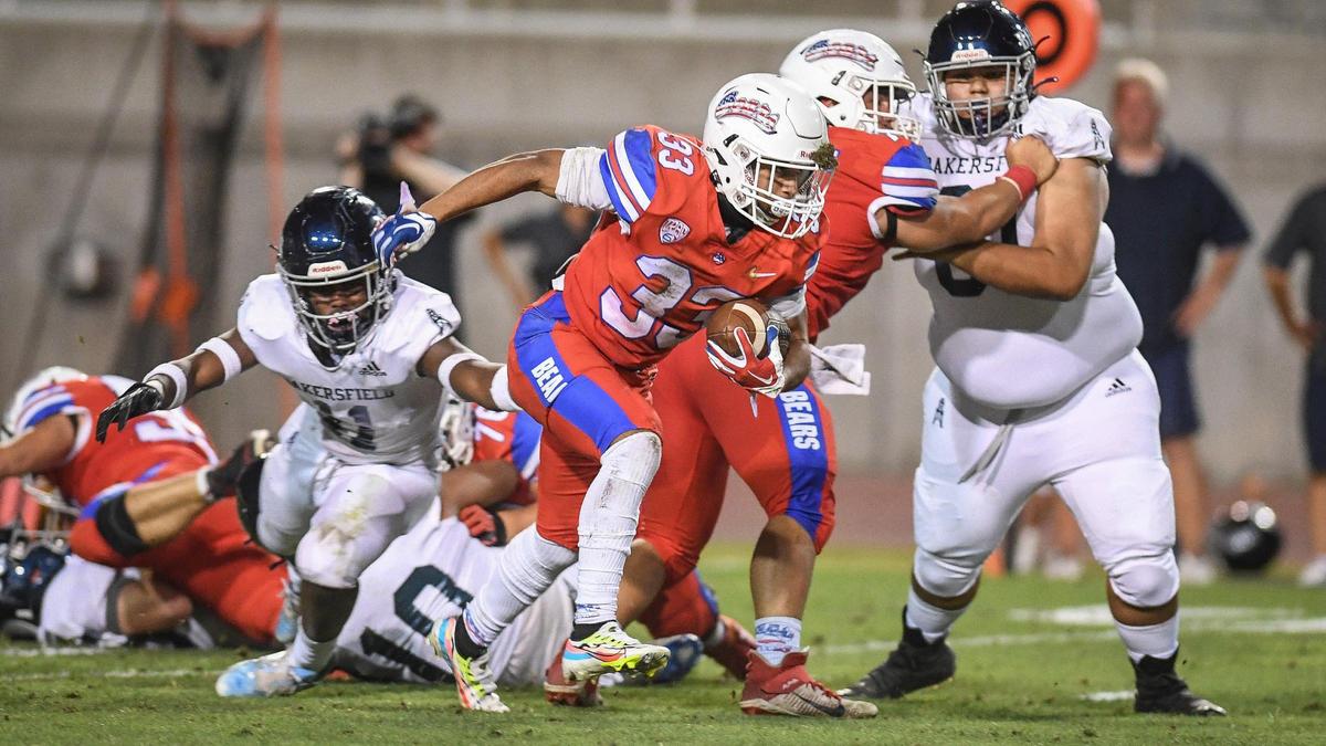 Buchanan’s Michael Runnels, center, gets past the Bakersfield line and eventually gets to the end zone for a long touchdown play in their game at Veterans Memorial Stadium on Friday, Aug. 19, 2022.