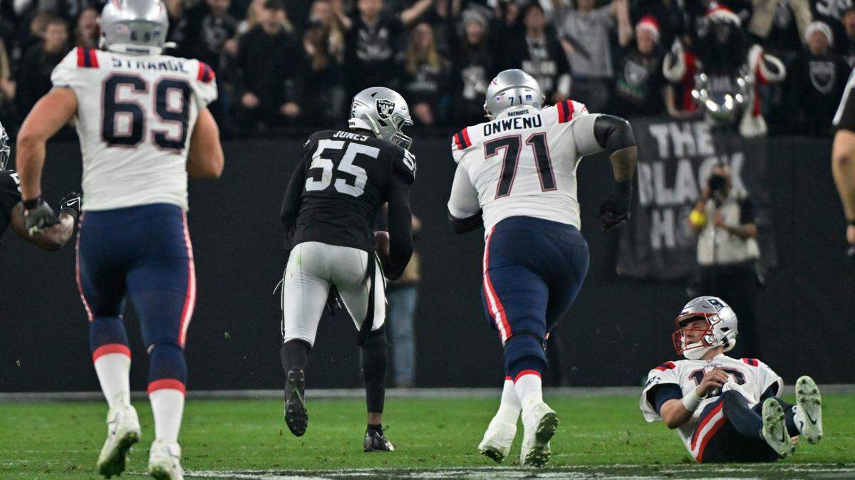 New England Patriots quarterback Mac Jones watches as Las Vegas Raiders defensive end Chandler Jones runs for a touchdown after an interception during the second half of an NFL game between the New England Patriots and Las Vegas Raiders, Sunday, Dec. 18, 2022, in Las Vegas. The Raiders defeated the Patriots 30-24.