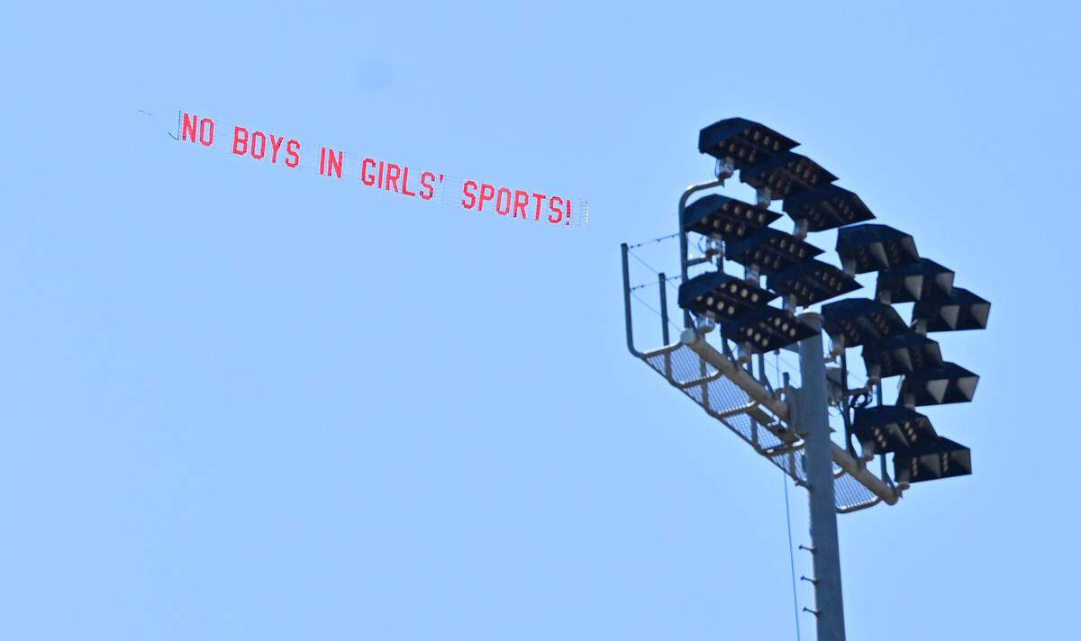 A banner is pulled by small plane circling over Veteran’s Memorial Stadium reading “No Boys in Girls’ Sports” pushing back against a trans athlete participating in the CIF Track & Field championship qualifying events Friday, May 30, 2025 in Clovis.  