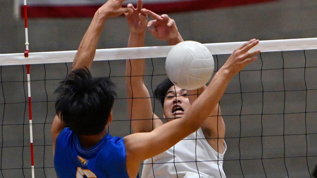 Clovis East’s Landon Moua, right, with Clovis High’s Justin Moua, left, in the Central Section Division I volleyball championship Thursday, May 11, 2023 in Clovis.