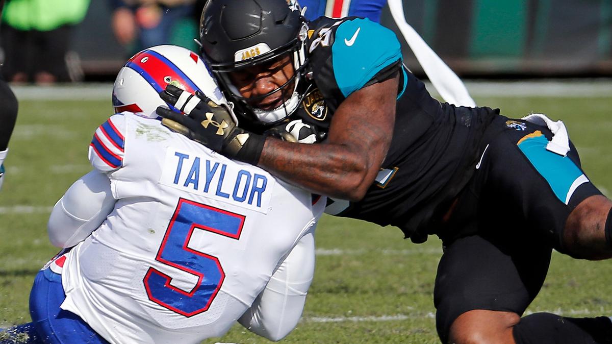 Jacksonville Jaguars defensive end Yannick Ngakoue, right, draws a penalty by hitting Buffalo Bills quarterback Tyrod Taylor (5) with helmet-to-helmet contact in the first half of an NFL wild-card playoff game last season, in Jacksonville, Fla. The preseason has been dominated by discussion about the “helmet rule.” Basically, any player on offense or defense lowering his head and making contact with any part of the helmet is subject to a 15-yard penalty, a fine, and even an ejection.