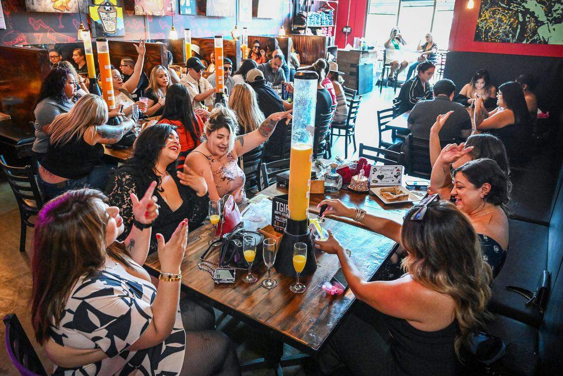 A packed house of brunch-goers sings and dances in their seats while sipping drinks from mimosa towers during Butta Brunch at Kocky's Bar & Grill in downtown Fresno on Sunday morning, Aug. 10, 2025.