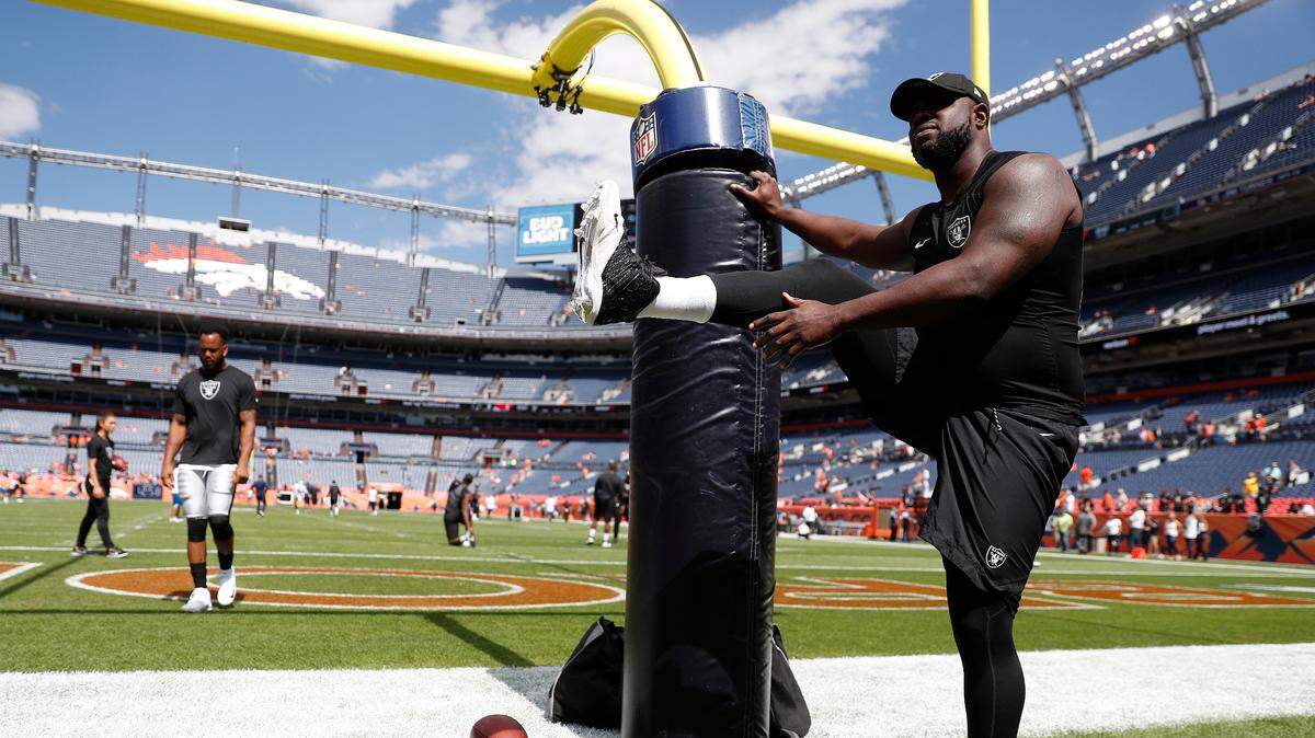 Oakland Raiders defensive tackle Clinton McDonald stretches prior to an NFL football game against the Denver Broncos, Sunday, Sept. 16, 2018, in Denver.