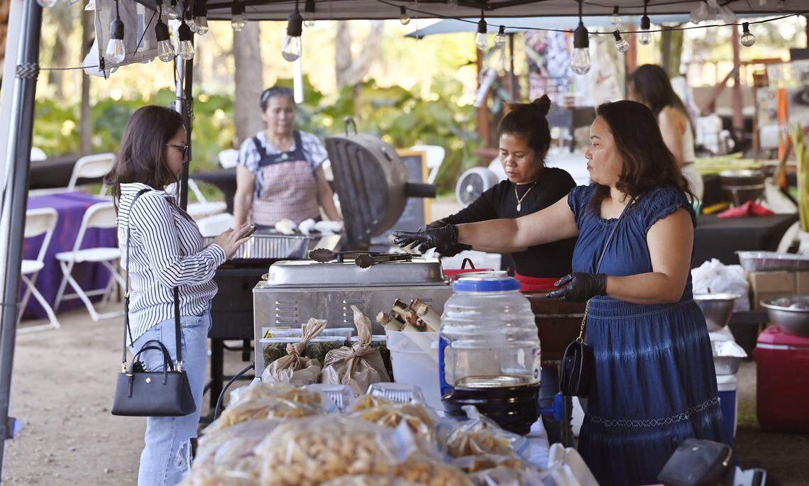 Food vendors serve a customer at Lotus Pond and Night Market which opened earlier this year celebrating the lotus flower and community. The night market, offering food and drinks, music and more, is located between Fresno and Sanger.