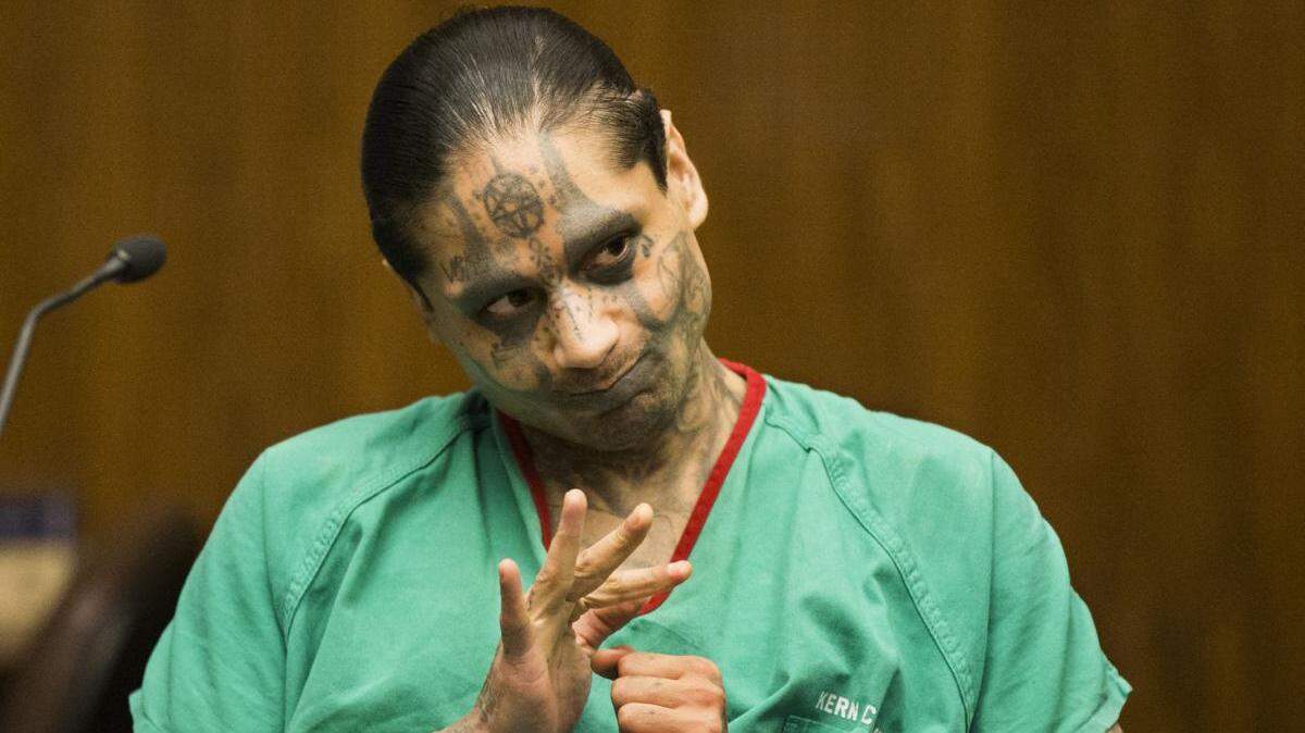 Jaime Osuna, the suspect in a homicide at Corcoran Prison, is shown in a 2017 photo from a court hearing, waving at the family of Yvette Pena, who he killed.
