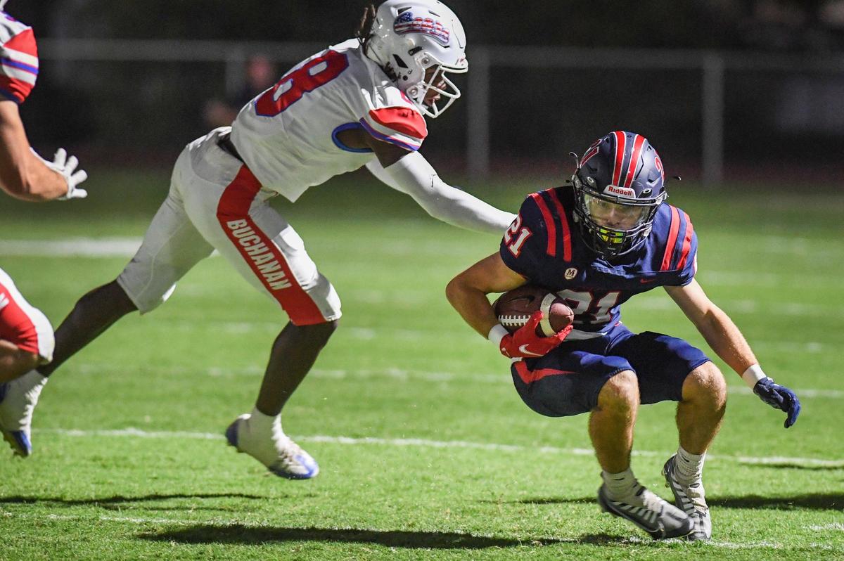 Memorial’s Ryan Wristen, right, tries to evade a tackle by Buchanan’s Mekhi Johnson on a catch along the sideline during their game at San Joaquin Memorial on Friday, Sept. 16, 2022.
