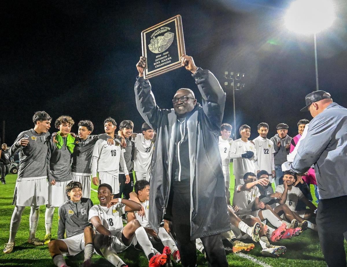 Edison boys soccer coach Femi Olukanni holds up the Division 1 soccer championship plaque after the Tigers defeated Clovis north in the final at Clovis North on Thursday, Feb. 27, 2025.