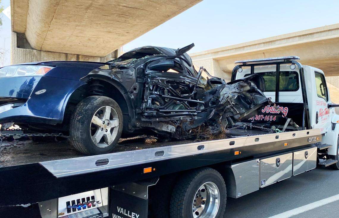 A car is removed from the scene after a crash on Highway 41 at the O Street off-ramp Saturday, Aug. 21, 2021, in Fresno, California.