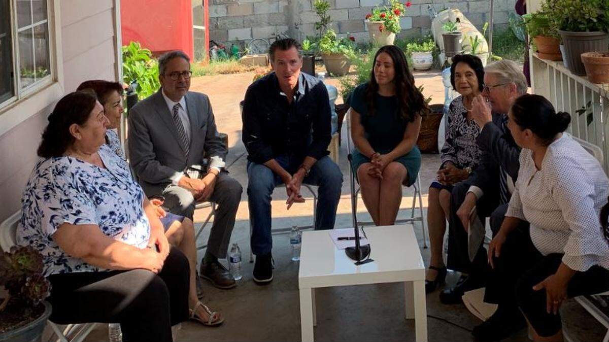 Gov. Gavin Newsom, center, is shown in the small Fresno County community of Tombstone Territory, speaking on water issues.