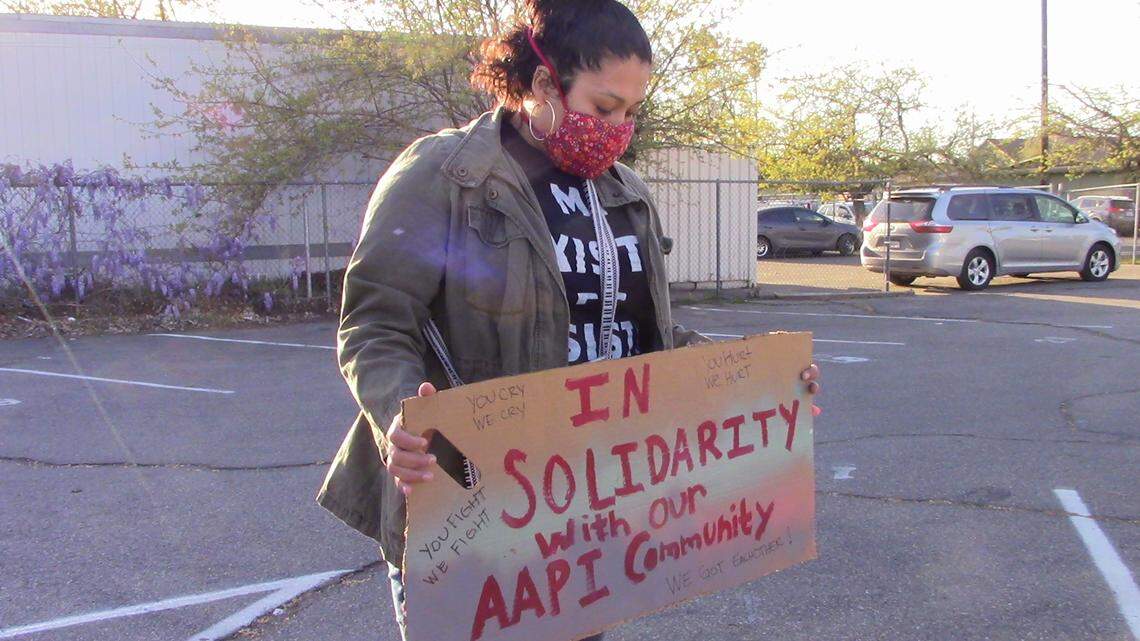 Alicia Gonzales holds up a sign during the Fresno, CA vigil for the eight Atlanta, Georgia victims.
