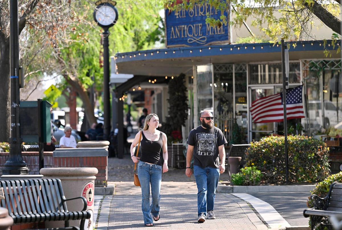 A father and daughter stroll along Pollasky Ave. Wednesday, March 26, 2025 in Old Town Clovis. Cowboy Cleanup will bring one hundred volunteers together to clean the streets, shops and intersections of Old Town Clovis on Saturday, March 29 in preparation for rodeo events in April.