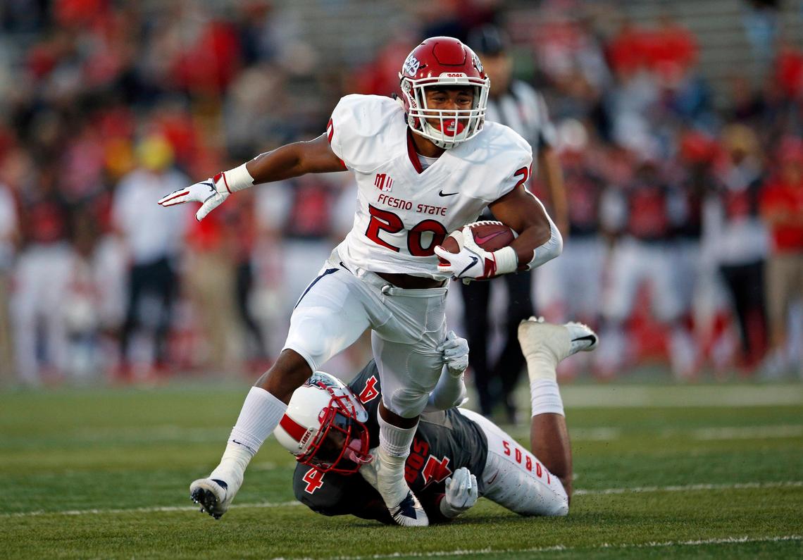 Fresno State running back Ronnie Rivers (20) eludes New Mexico safety Bijon Parker (4) before scoring a touchdown in the Bulldogs’ 38-7 victory over the Lobos in Albuquerque, N.M., Saturday, Oct. 20, 2018. Rivers scored three touchdowns in the win, two rushing and one receiving.