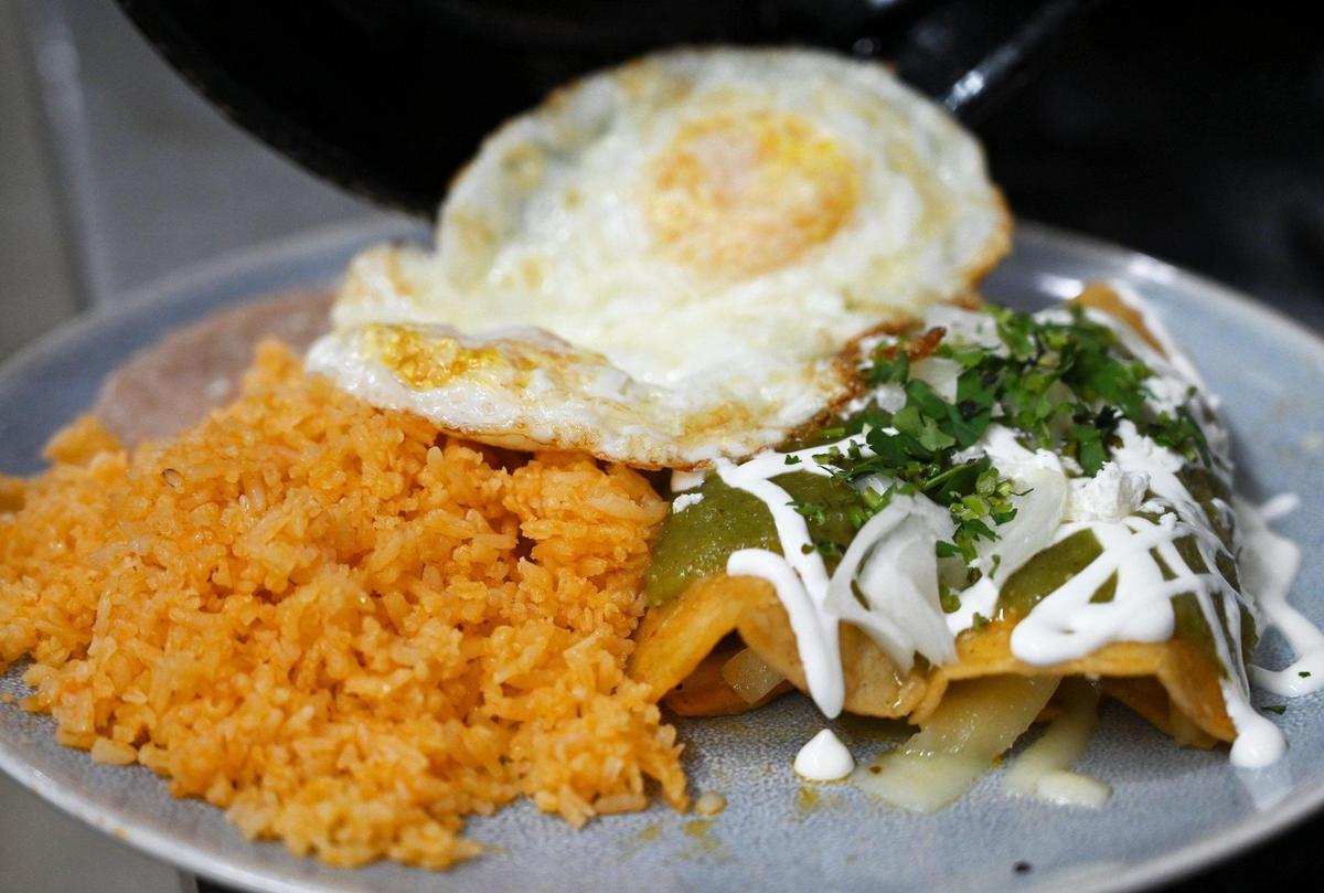 Chicken enchiladas montadas at Qué Pasó Camarón? includes fried eggs with beans and rice. Photographed Thursday, April 14, 2022 in Fresno.