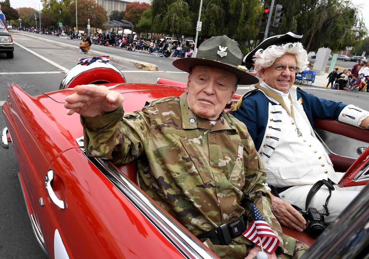 96-year-old World War II Navy veteran Ed Bates (the former Madera County sheriff) waves to the crowd from a 1956 Thunderbird driven by George Washington (Navy veteran Larry Duba) during the Central Valley Veterans Day Parade, Thursday Nov. 11, 2021.