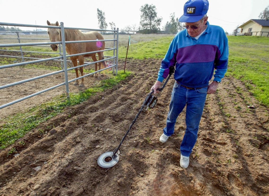 BONADELLE RANCHOS, CA 2-4-2004 - MTD JRW WWII SHELLS DETECT- Cecil Ray uses his metal detector on his property in the Bonadelle Ranchos subdivision, in search of WWII shell casings Thursday afternoon. Once the site of a World War II bombing and shooting target range (ck terminology), he’s found many casings including 50-caliber and a 20-mm behind his home. JOHN WALKER/FRESNO BEE