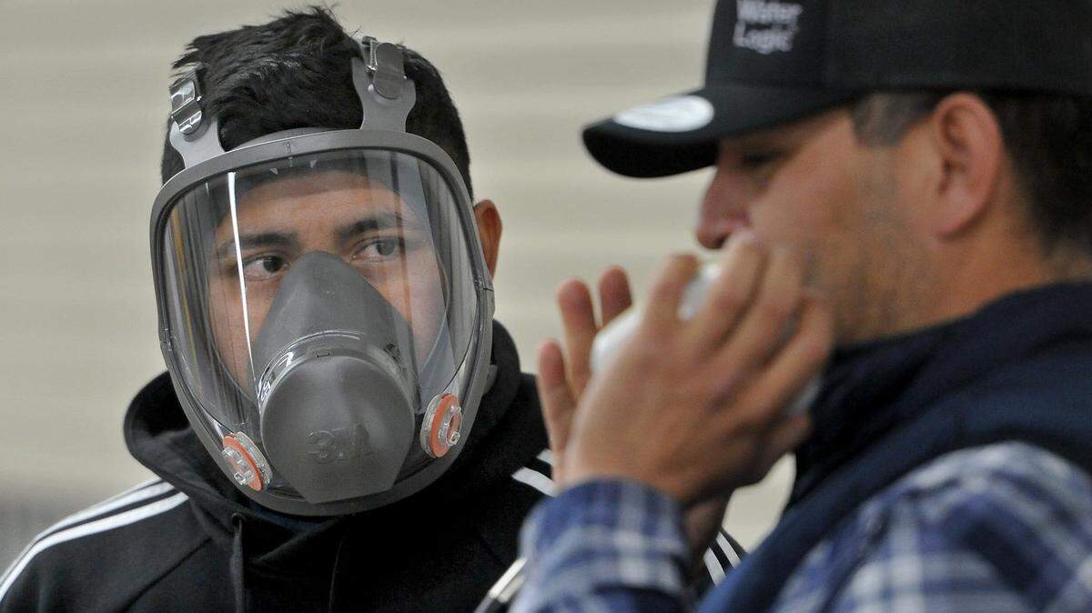 Jesus Garcia, left, a licensed pesticide control applicator and farm worker in Madera, dons the latest in respirators as he listens to a presentation by Francisco Rivera, of Simplot Grower Solutions, during the spray safe workshop at the Big Fresno Fairgrounds in 2019. The workshop, attended by around 250, brought together the agricultural community, farmers, employees, pest control advisors and applicators, as well as Mike Stoker, EPA regional administrator and state Sen. Melissa Hurtado, to encourage the safe application of pesticides through education.