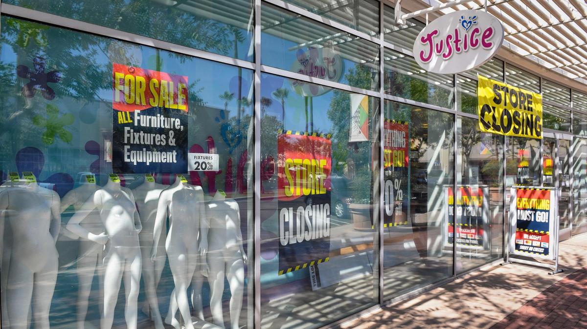Mannequins for sale appear in the window and store closing signs cover the Justice tween clothing store at River Park shopping center on Wednesday, Aug. 5, 2020.