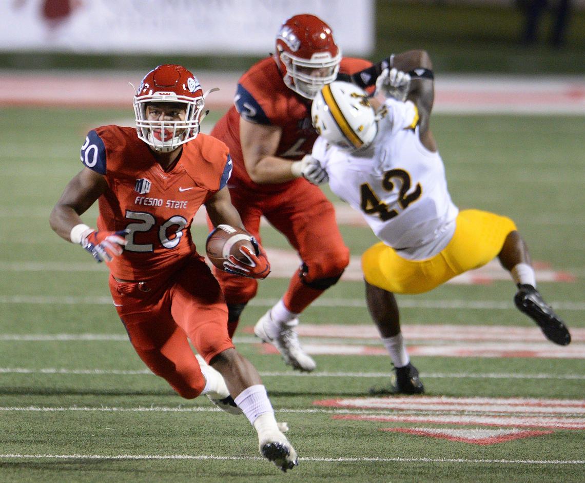 Fresno State running back Ronnie Rivers, left, dashes down field on a long run while left guard Logan Hughes buries a Wyoming defender with a block during the Bulldogs’ 27-3 victory over the Cowboys at Bulldog Stadium in Fresno on Saturday, Oct. 13, 2018.