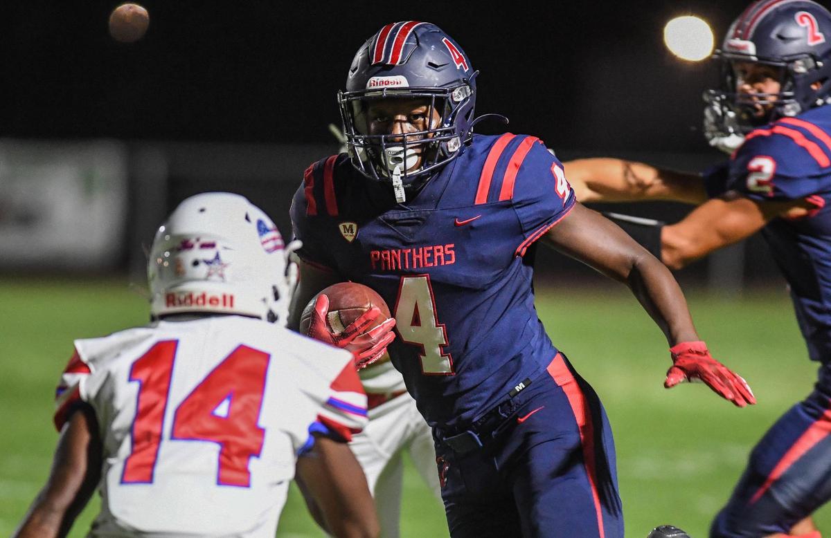 Memorial’s Jordan Colbert, center, tries to get by Buchanan’s Jace Davies on a pass to the outside during their game at San Joaquin Memorial on Friday, Sept. 16, 2022.