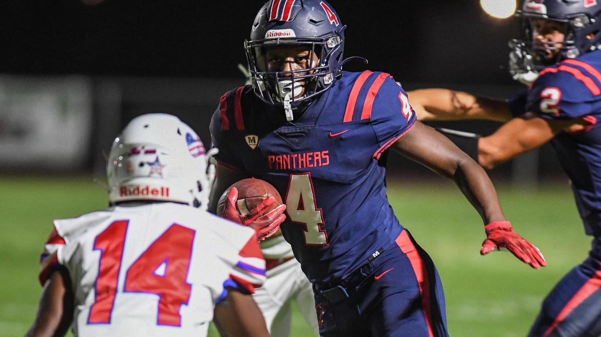 Memorial’s Jordan Colbert, center, tries to get by Buchanan’s Jace Davies on a pass to the outside during their game at San Joaquin Memorial on Friday, Sept. 16, 2022.