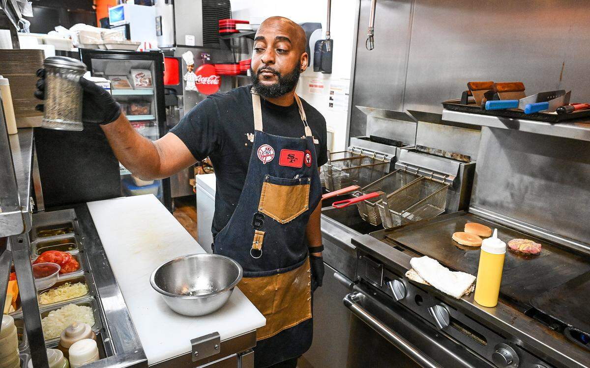 Jay Shelton, co-owner and manager of Weekend Dreams Burgers & Grill, prepares an order at the west Fresno restaurant on Wednesday, Nov. 19, 2025.